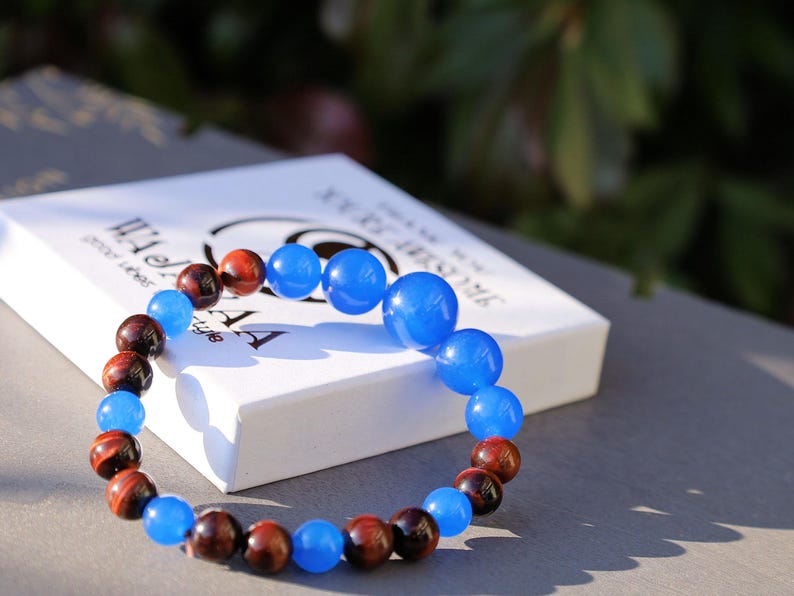 A bracelet made with Royal Blue Jade and Red Tiger Eye beads is a striking combination that blends elegance and vibrant energy.