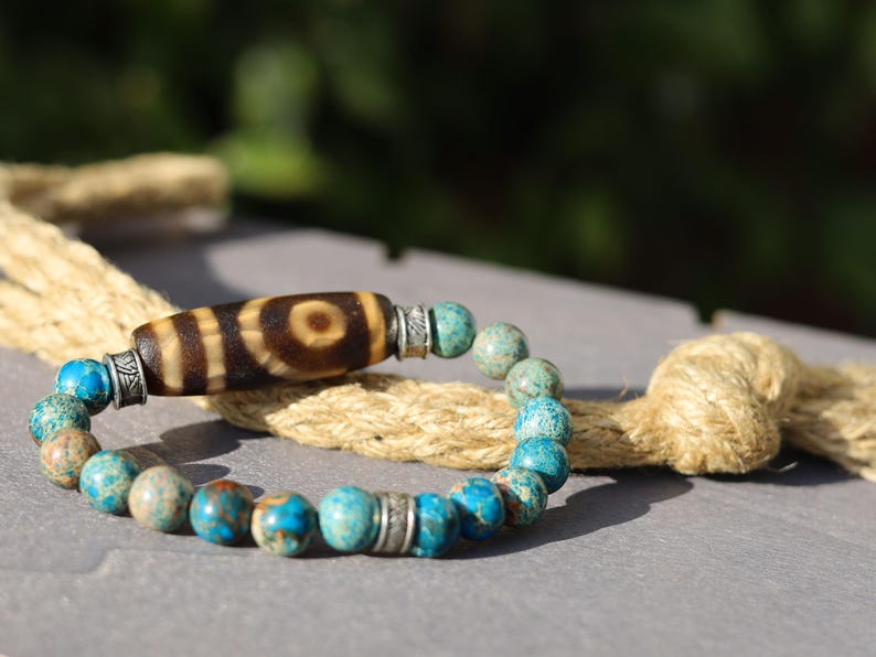 Old Two-eye dZi bead Bracelet with African Turquoise beads.  visually striking but also imbued with profound spiritual significance