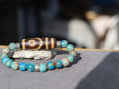 Old Two-eye dZi bead Bracelet with African Turquoise beads.  visually striking but also imbued with profound spiritual significance