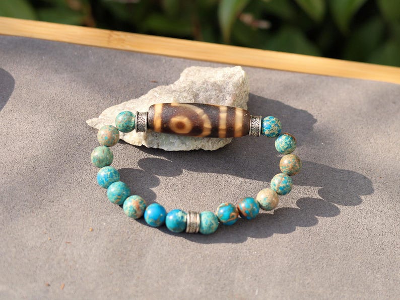 Old Two-eye dZi bead Bracelet with African Turquoise beads.  visually striking but also imbued with profound spiritual significance