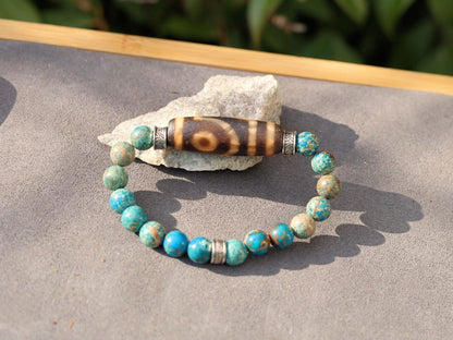 Old Two-eye dZi bead Bracelet with African Turquoise beads.  visually striking but also imbued with profound spiritual significance