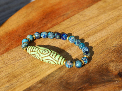 Tibetan Six Phoenix’s Eyed Bracelet – Hand-Carved Turquoise with Sea Sediment Turquoise Bead. Transformation, protection, and enlightenment.